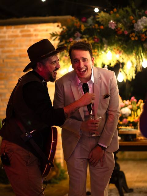 Vocalista dos Folkadelicos cantando com um convidado na festa