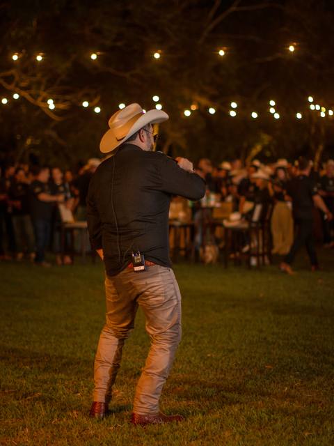 Vocalista dos Folkadelicos cantando no gramado de uma festa à noite